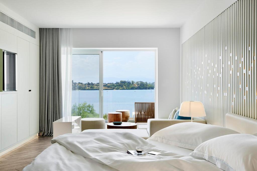 a bedroom with two beds and a large window at Nikki Beach Resort & Spa in Porto Heli