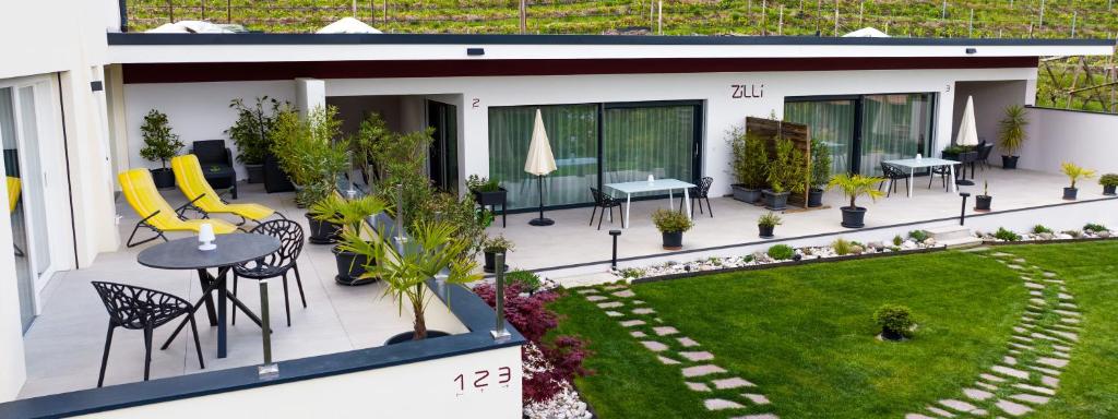 una casa con patio arredato con sedie e cortile di Zilli Studio Apartments a Termeno