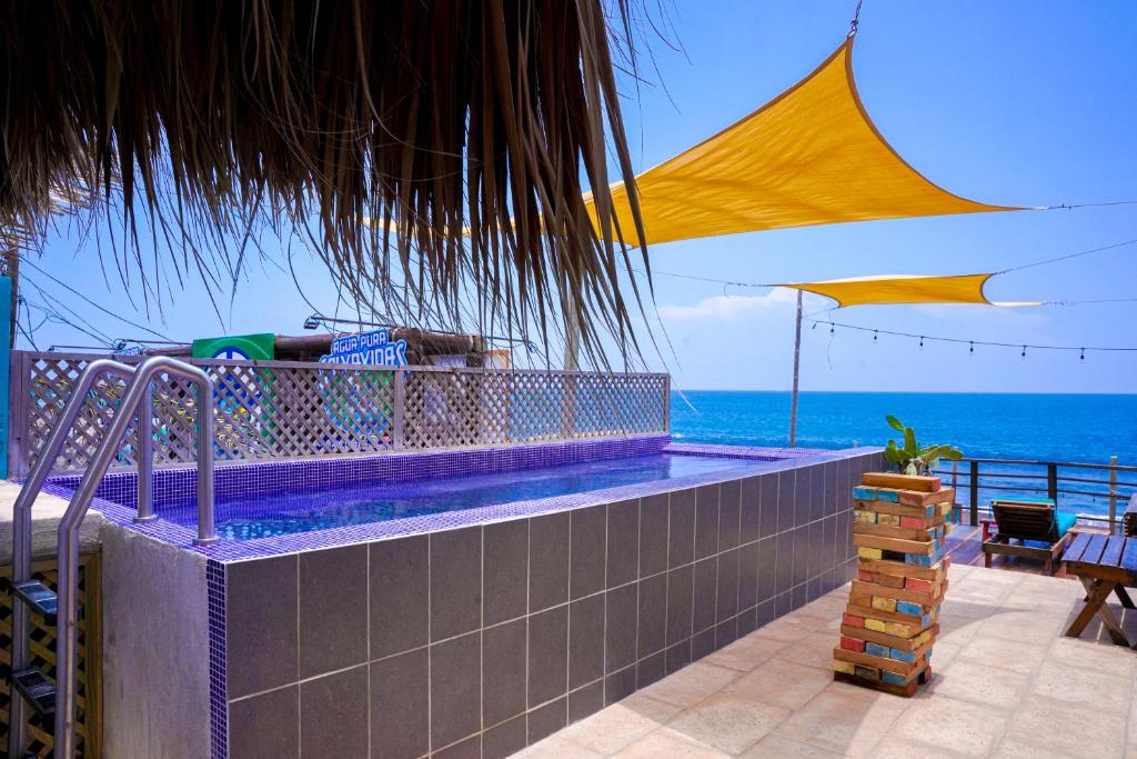 a swimming pool with a view of the ocean at Black Sand Beachhouse in Monterrico