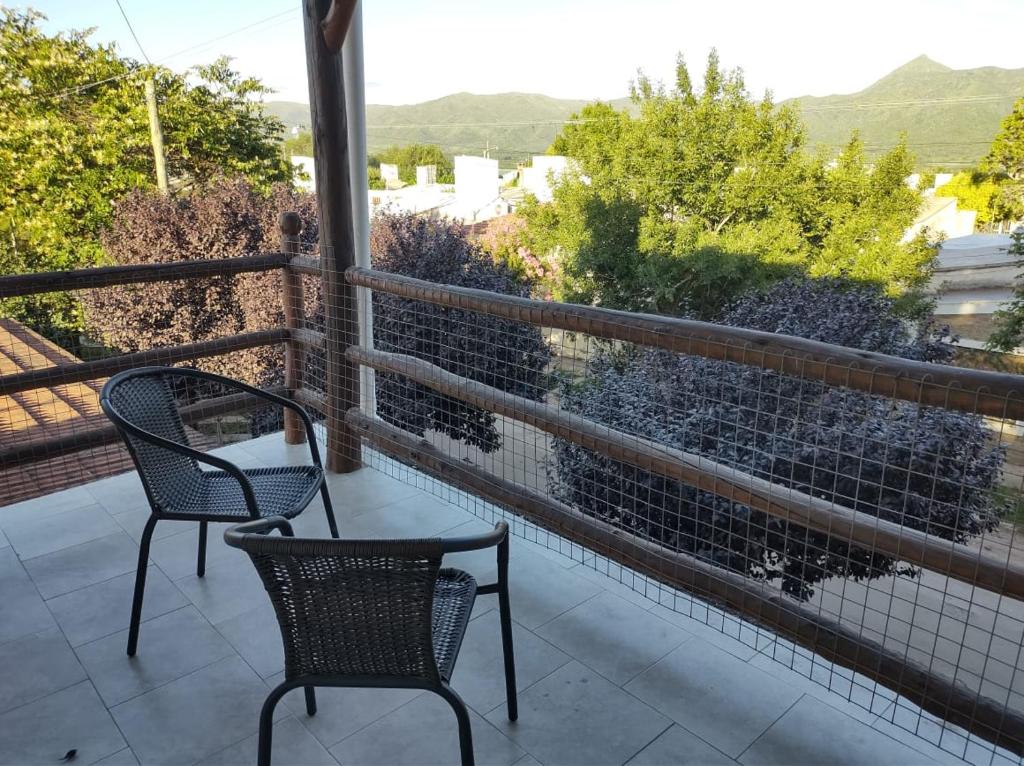 uma varanda com 2 cadeiras e vista para as montanhas em Cabaña Céntrica con Balcón Vista a las Sierras em Cosquín