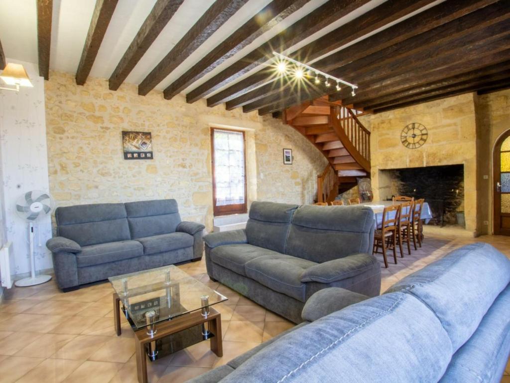 a living room with blue couches and a table at Gîte Domme, 5 pièces, 8 personnes - FR-1-616-23 in Domme