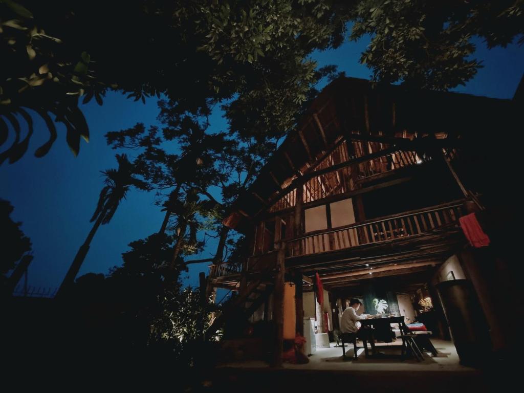 a man sitting at a table in front of a building at Mô he in Sơn Tây