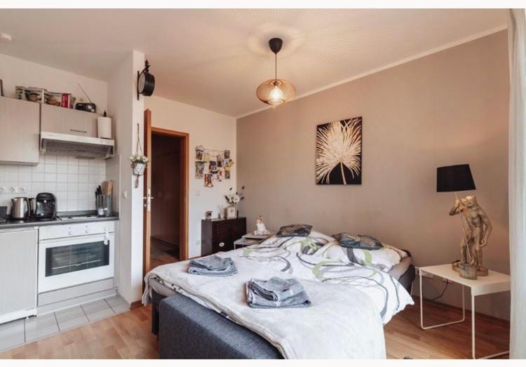 ein Schlafzimmer mit einem Bett und eine Küche mit einem Tisch in der Unterkunft Die kleine „Louise“ in der Neustadt mit Tiefgarage in Dresden