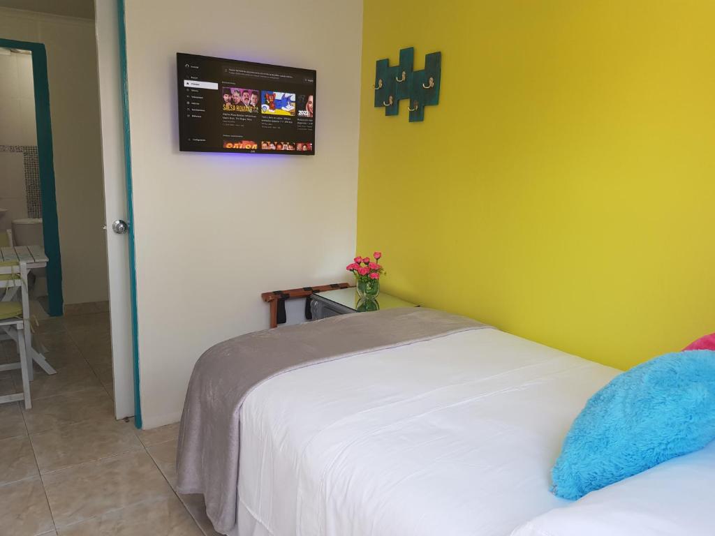 1 dormitorio con 2 camas y TV en la pared en The Jazmine's Apartment, en Oranjestad