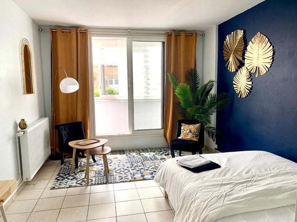 a bedroom with a bed and a table and a window at Studio Cosy Cahors- proche Gare et Centre-Ville in Cahors