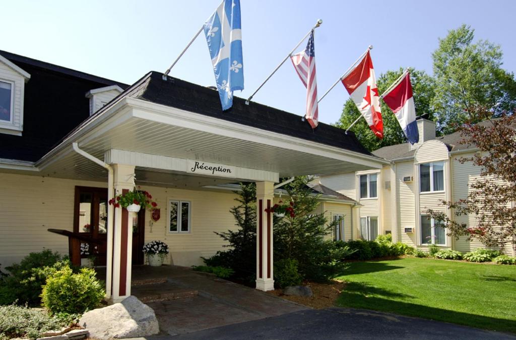 a house with flags on the front of it at Relais St-Denis in Saint-Sauveur-des-Monts