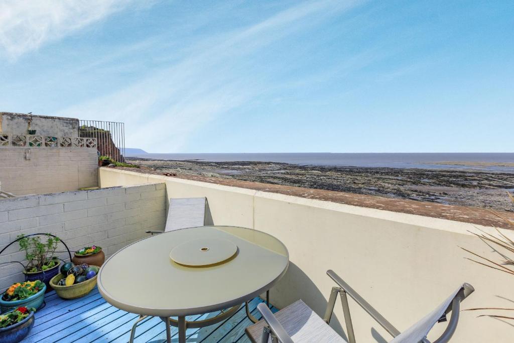 a table and chairs on a balcony with a view of the ocean at Sea Spray in Watchet