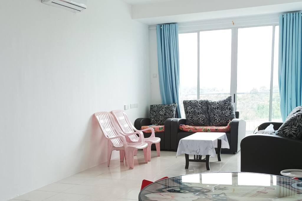 a living room with a couch and chairs and a table at Ike village in Kota Samarahan