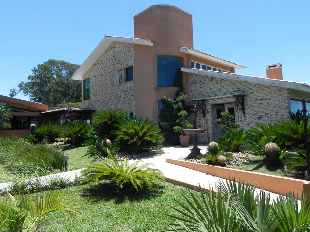 a house with a garden in front of it at A Casa dos Hóspedes in Capão da Canoa