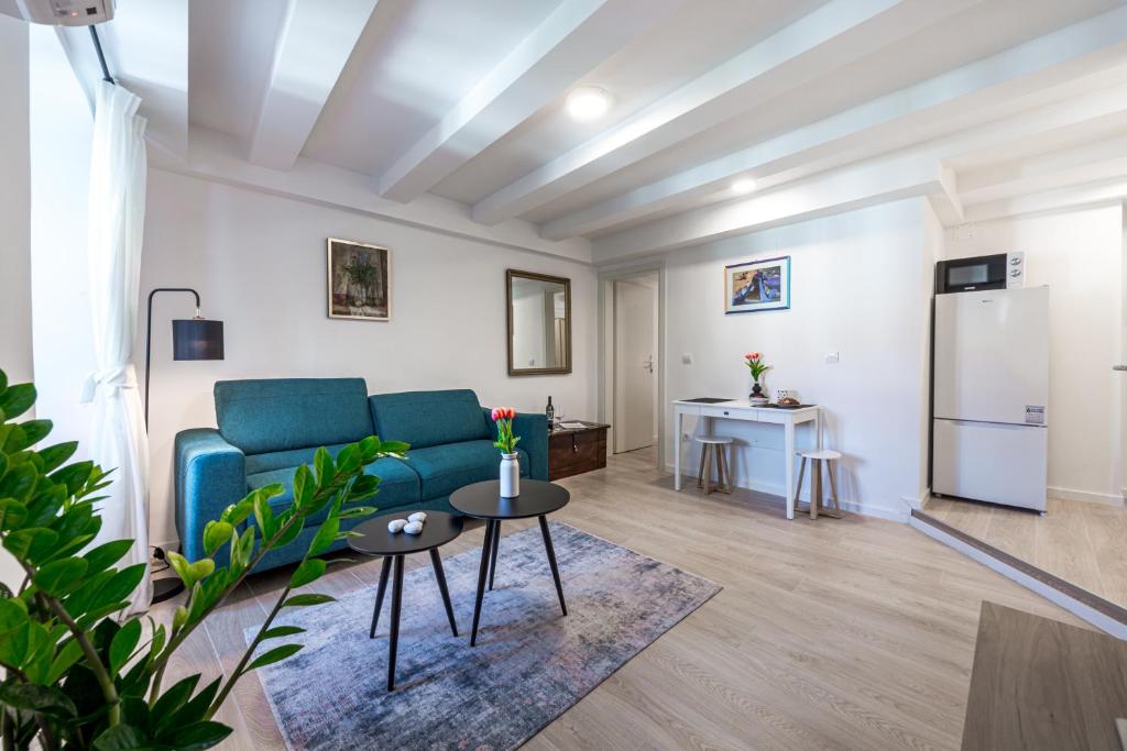 a living room with a blue couch and a refrigerator at Rooms Andro in Dubrovnik