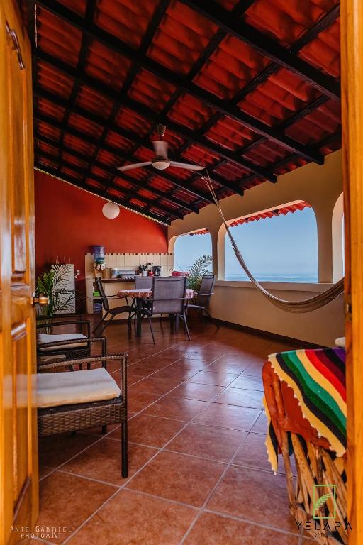 a living room with a table and chairs and red walls at Casa Vista Magica in Yelapa