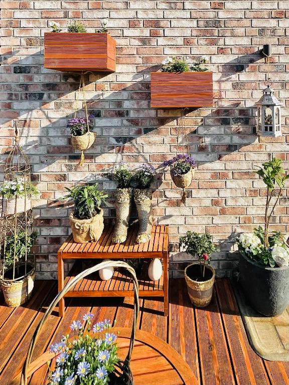 a brick wall with potted plants on a patio at Extravagantes Apartment in Potsdam