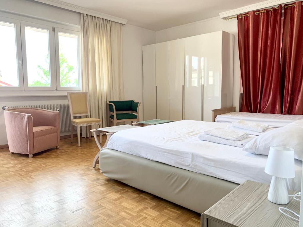 een slaapkamer met een groot bed met rode gordijnen bij Appartamento Bolzano - Vittorio Veneto - Parcheggio incluso in Bolzano