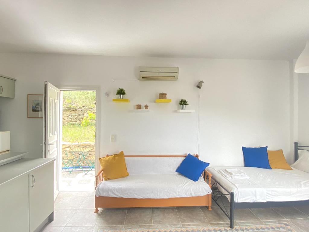 Cette chambre comprend 2 lits et une table. dans l'établissement Andros Vineyard house with sea view, à Sinétion