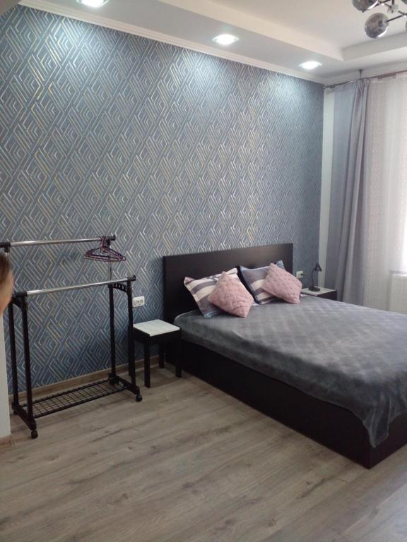 um quarto com uma cama e uma parede em Апартаменты в центре города em Chernivtsi