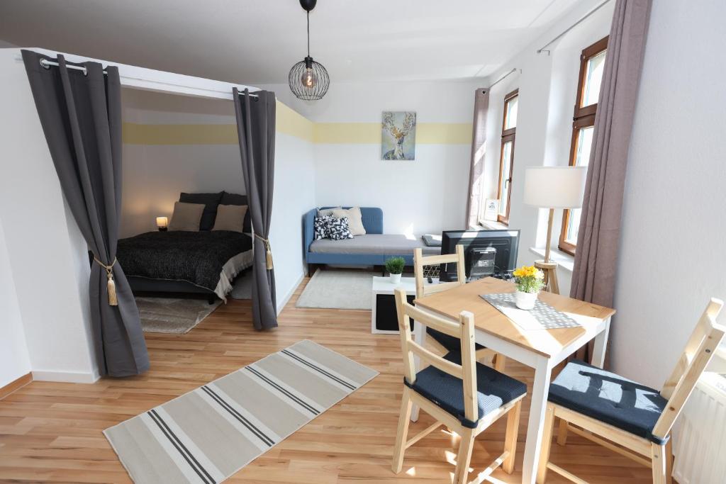 sala de estar con mesa y dormitorio en FULL HOUSE Studios - Little Mill Apartment - WiFi, en Chemnitz