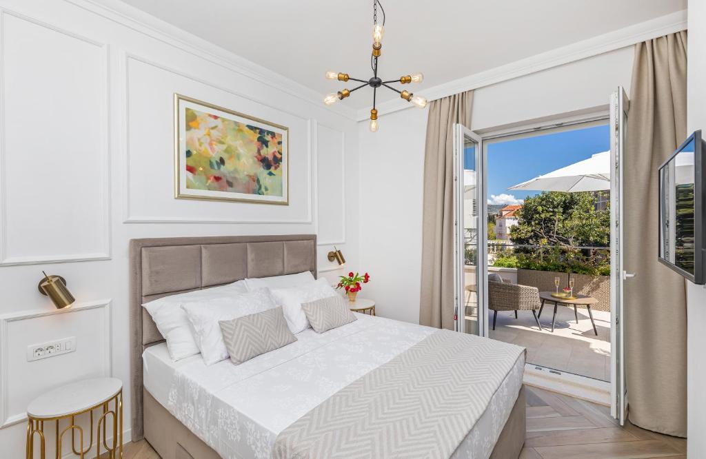 Habitación blanca con cama y balcón. en Rooms D&L, FREE Parking on-site, en Dubrovnik