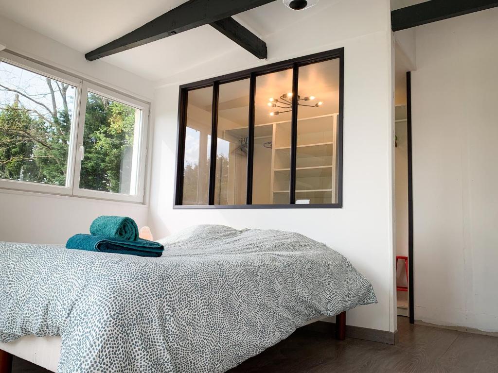 une chambre avec un lit et une fenêtre dans l'établissement Ker Gaouenn - moderne & cosy (pergola, jardin, terrasse géante...) - bonne connexion - intime (guide personnalisé en cadeau), à Les Fougerêts