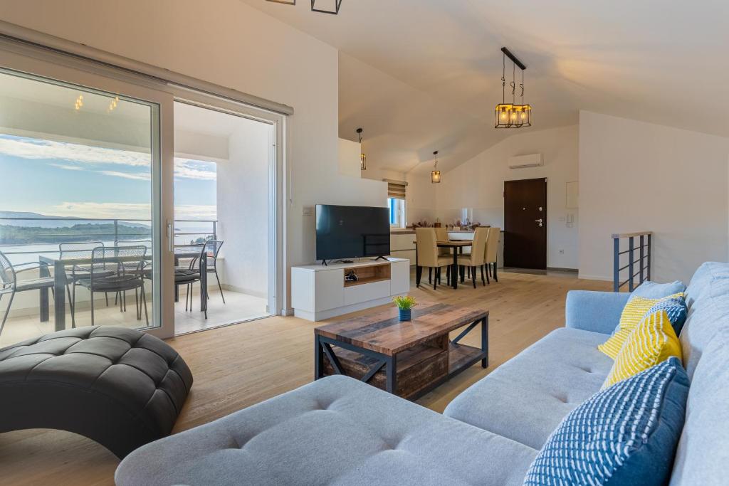 een woonkamer met een bank en een tafel bij Best Sea View Apartment in Cres