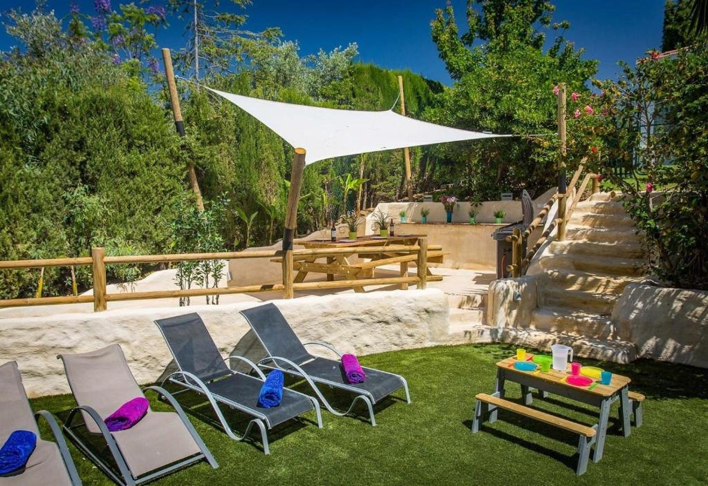 grupa krzeseł, stół i parasol w obiekcie Casa Eucalyptus Family Home w mieście Estepona