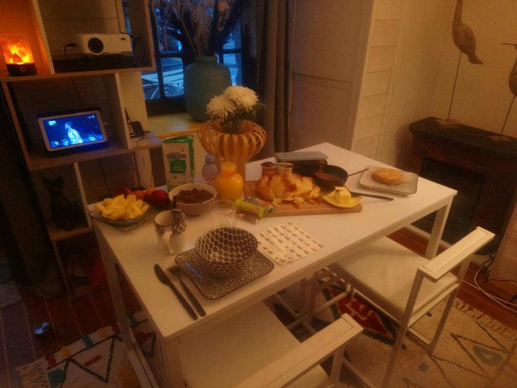una mesa blanca con comida en la cocina en Bienvenue, en Saint-Pierre-de-Plesguen