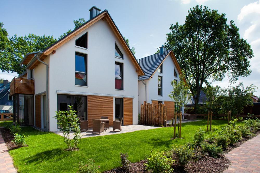een wit huis met een patio en een tuin bij Domizil am Ostseewald - Huflattich in Zingst