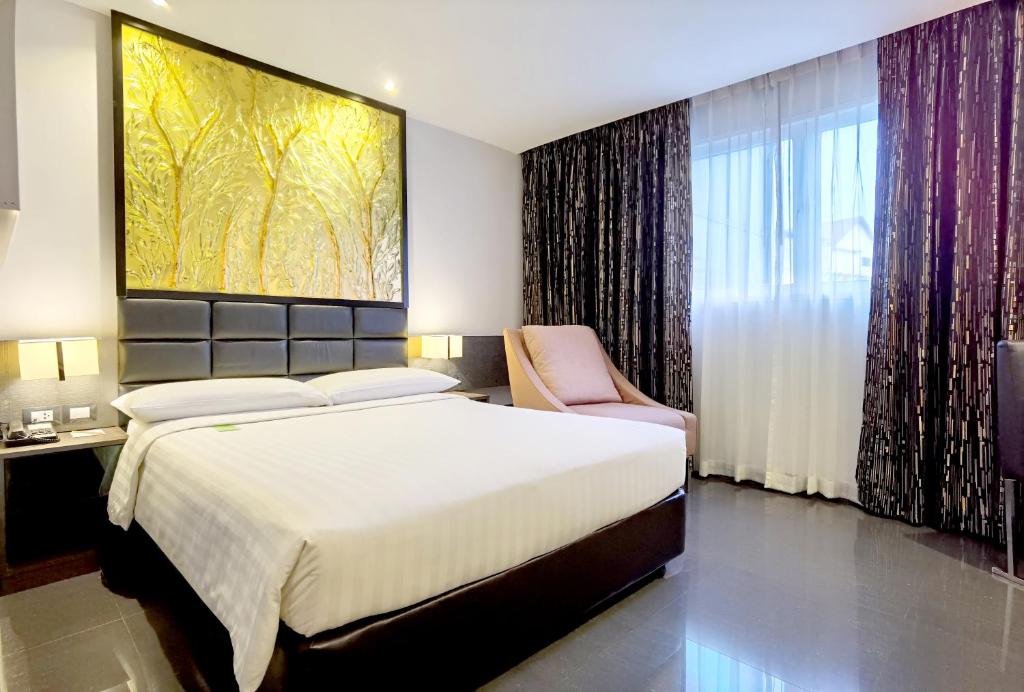 Postel nebo postele na pokoji v ubytování Nova Express Pattaya Hotel