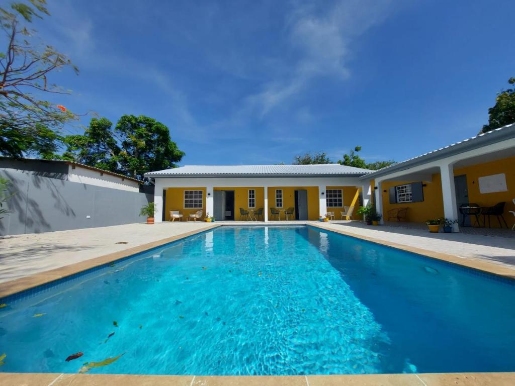 a swimming pool in front of a house at J&L Resort in Willemstad
