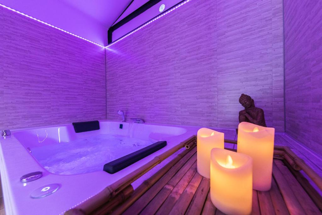 a bathroom with a tub with purple lighting and candles at Zen & Spa - Maison Cosy - Tours - Netflix in Tours