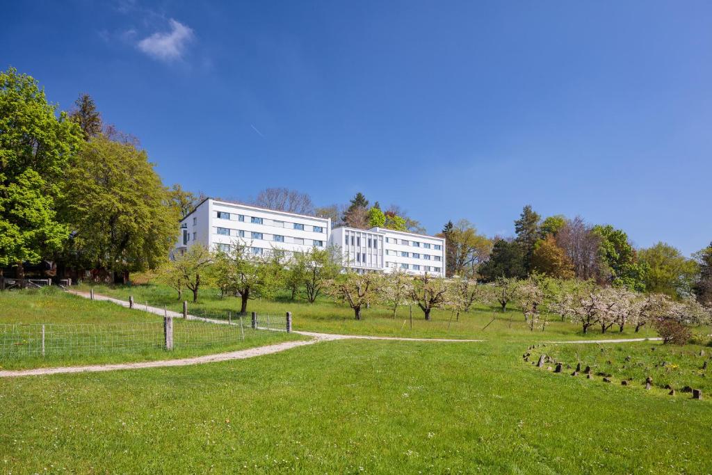 a building in the middle of a park with trees at Le Domaine (Swiss Lodge) in Fribourg