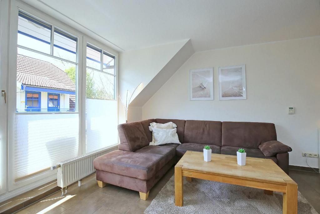 a living room with a brown couch and a coffee table at Papillon Wohnung 04-5 in Boltenhagen