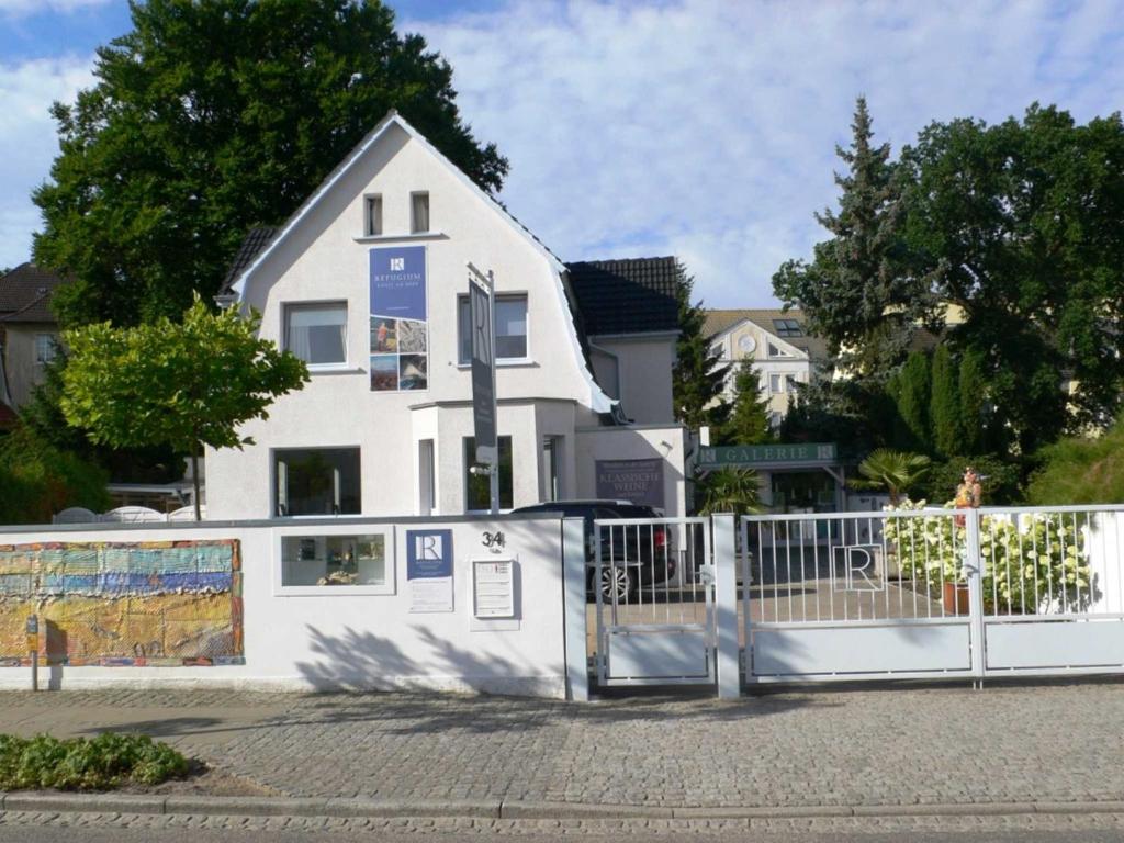 une clôture blanche devant une maison blanche dans l'établissement Refugium Erholung am Meer, à Zinnowitz