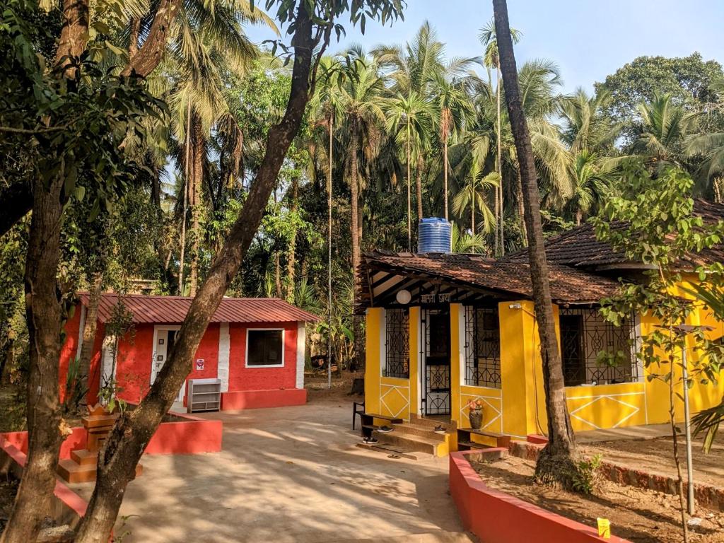 a couple of small buildings in front of palm trees at BunkNBrew in Palolem
