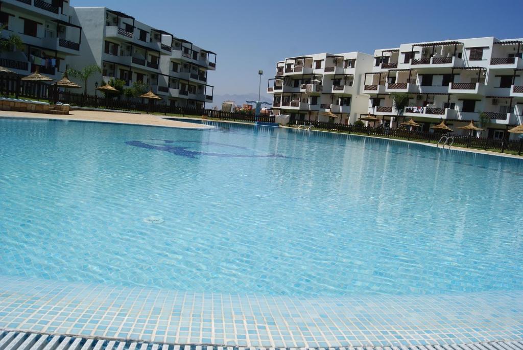 uma grande piscina em frente a alguns edifícios de apartamentos em Appartement Miradorgolf em Cabo Negro