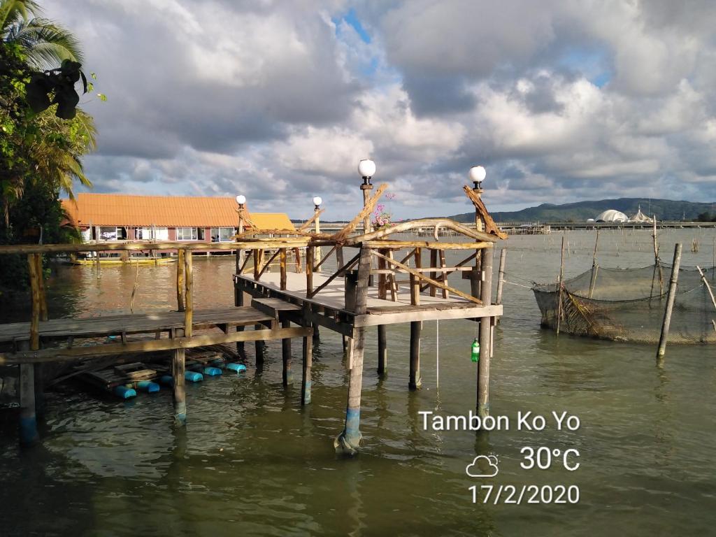 een houten dock in een waterlichaam bij โฮมสเตย์เรือนเจ้าจอม in Ban Bo Hin