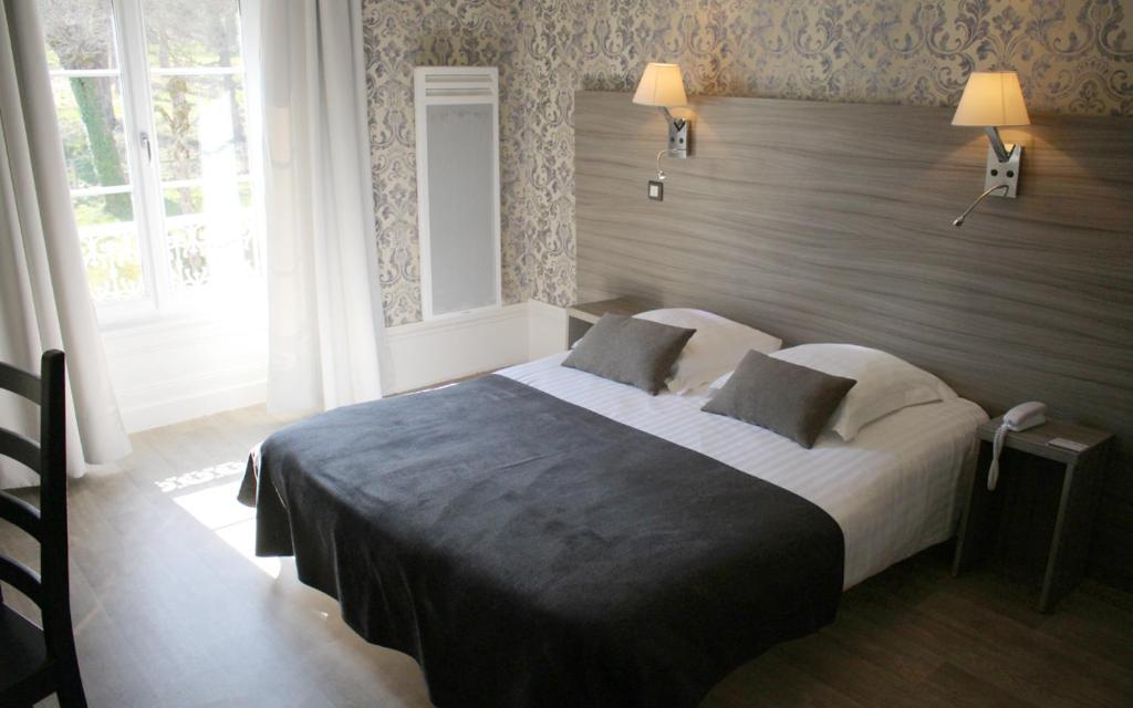 
A bed or beds in a room at Logis Grand Hôtel Bourbon-Lancy
