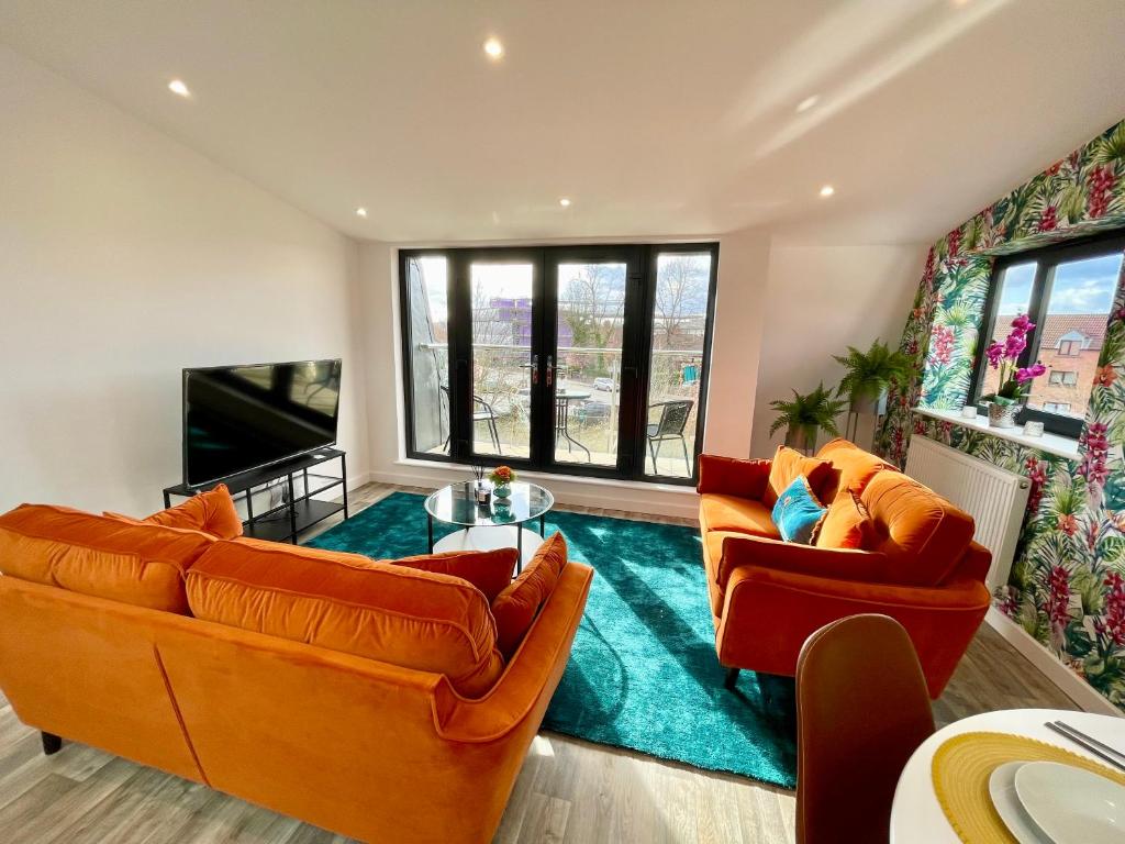 a living room with two orange couches and a blue rug at Minster Peek With Free Parking in York