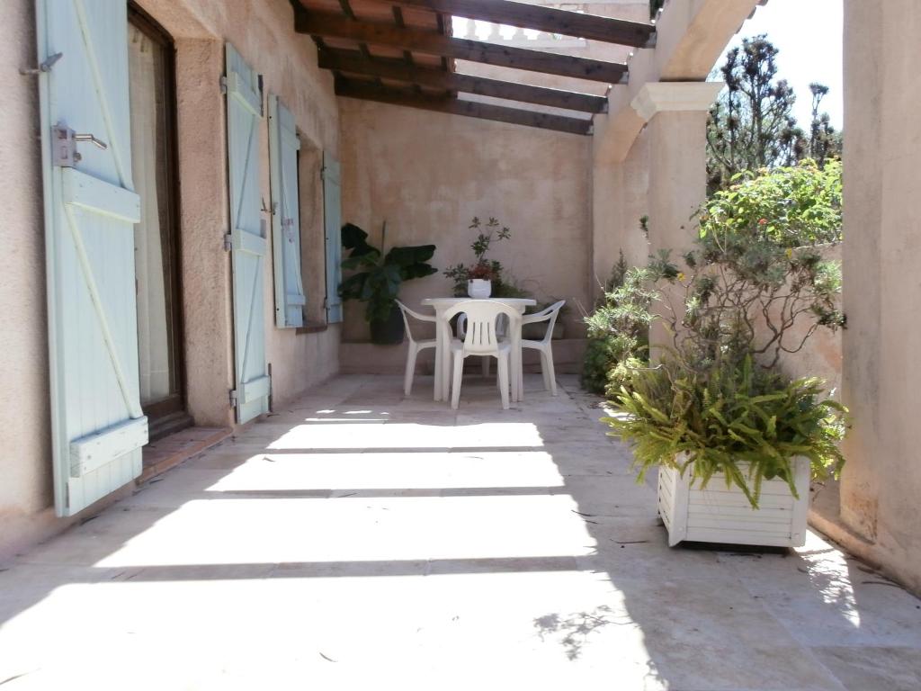 un patio en una casa con mesa y sillas en Rez de Villa Climatisé avec Jardin Privatif Domaine des Moulières en La Valette-du-Var