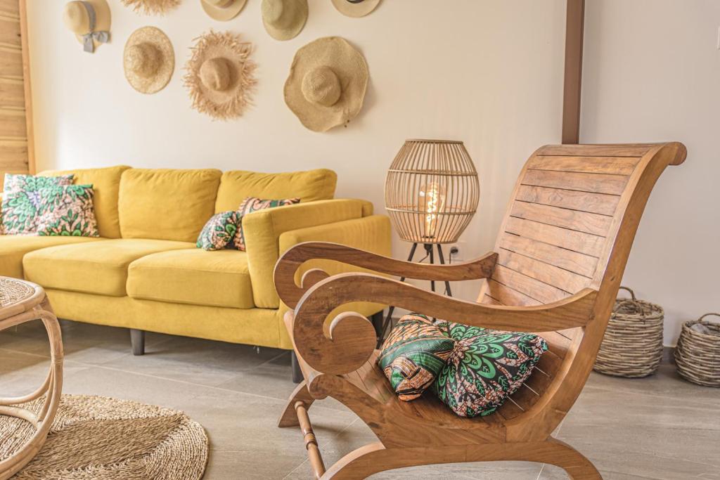 a living room with a couch and a rocking chair at Ti Kaz Lontan - La Rivière in Saint-Louis