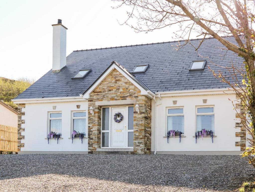 a house with a stone facade and windows at Wisteria Cottage in Annagry