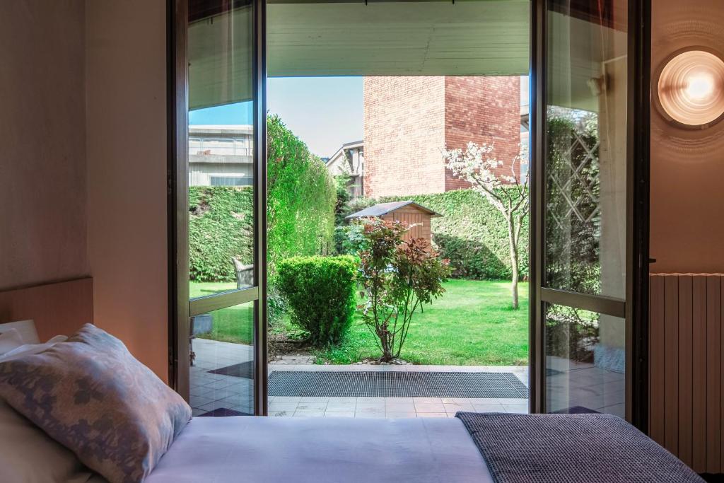 sypialnia z łóżkiem i przesuwanymi drzwiami szklanymi w obiekcie My Sweet Garden - by MyHomeInComo w mieście Cassina Rizzardi