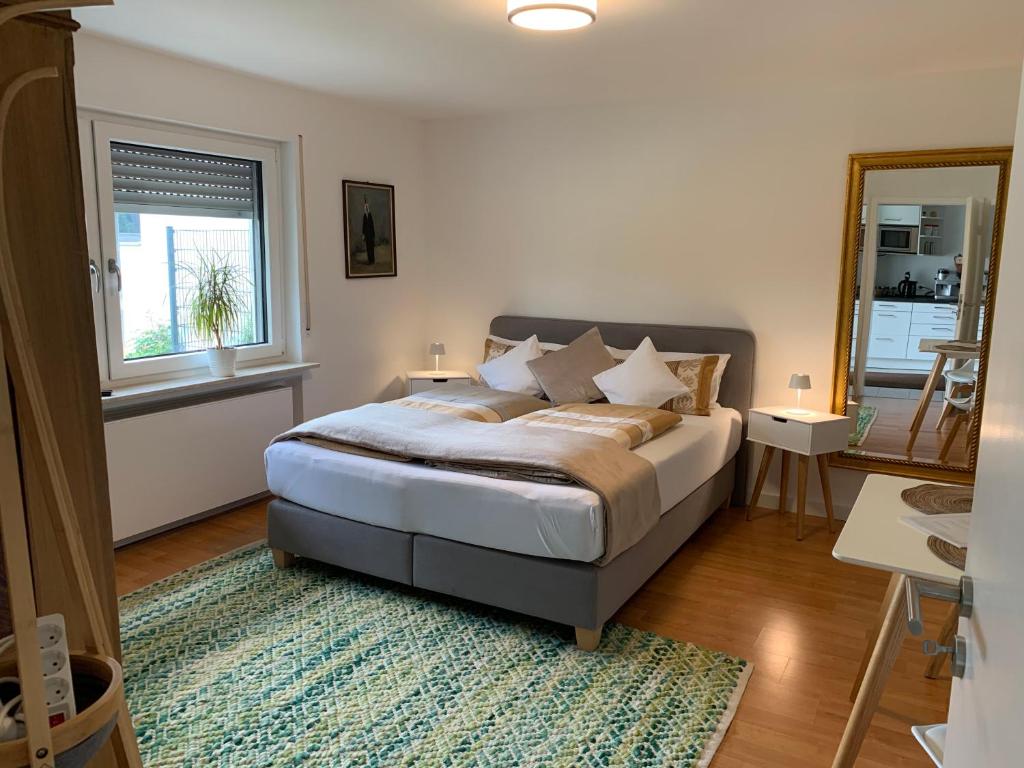 1 dormitorio con cama, ventana y alfombra en Apartment nähe Ettlingen - 15 min zur Messe Karlsruhe en Malsch
