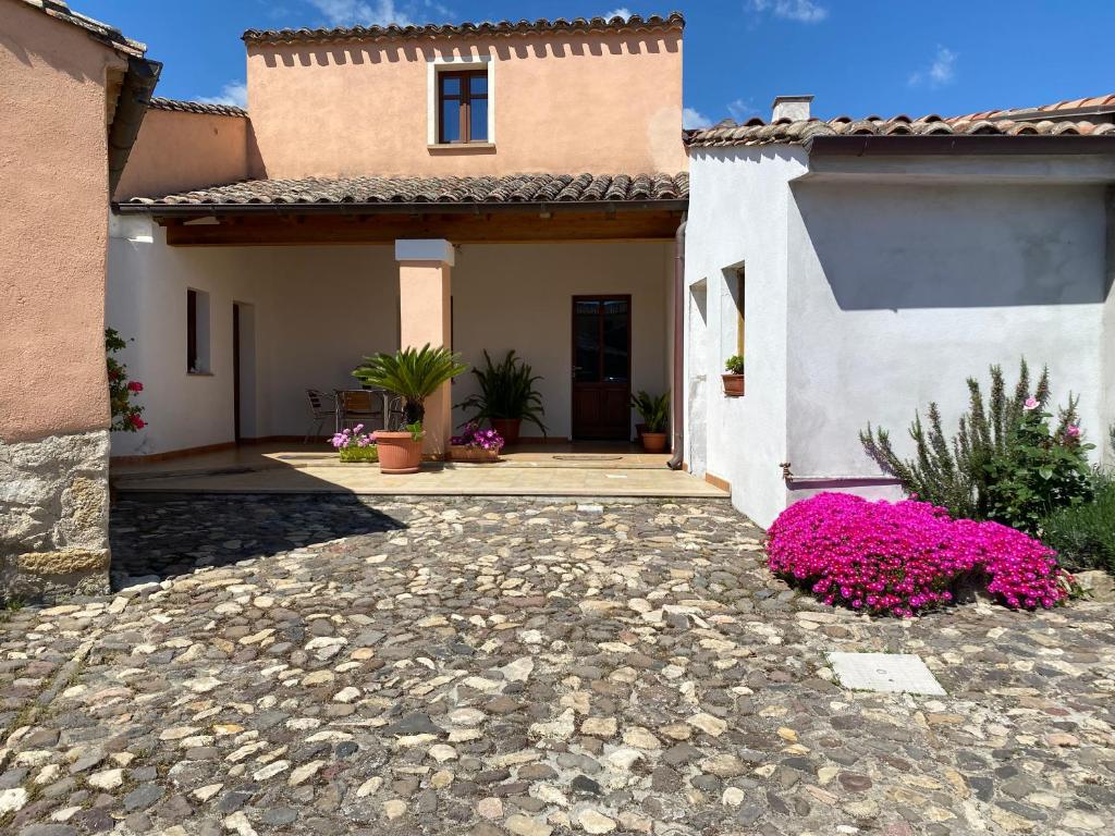 una casa con flores rosas delante de ella en B&B Domenico Paulis, en Tuili