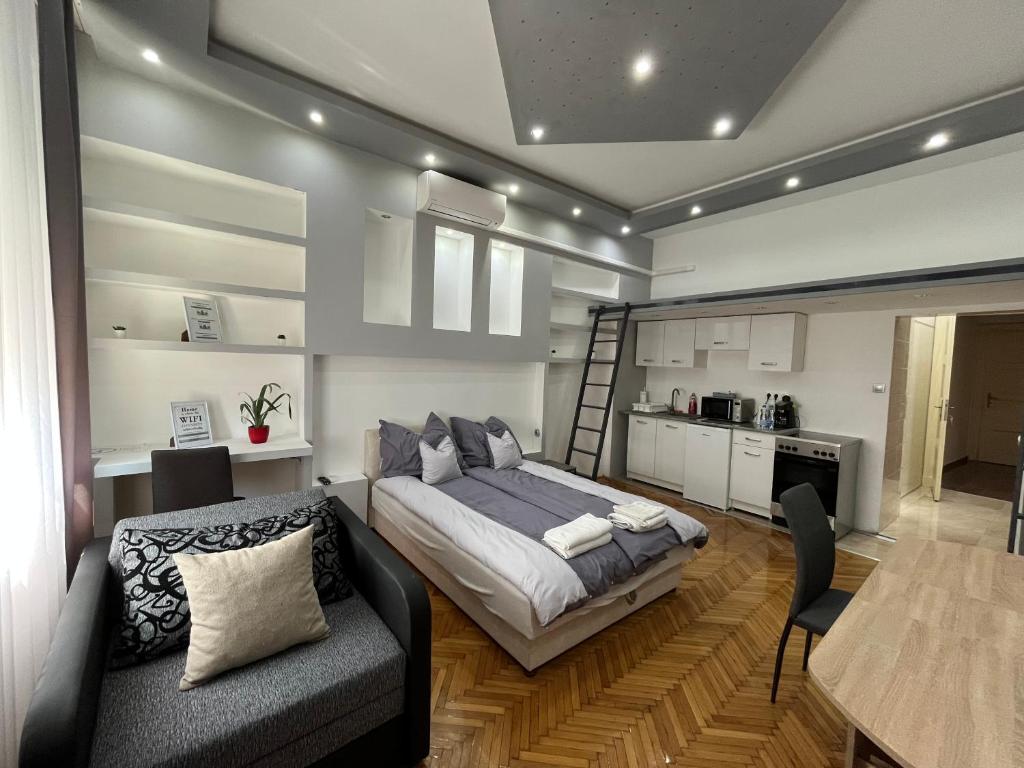 Cet appartement comprend une chambre avec un lit et une table ainsi qu'une cuisine. dans l'établissement Széchenyi Apartman (III. Panorama) Miskolc belvárosában, à Miskolc