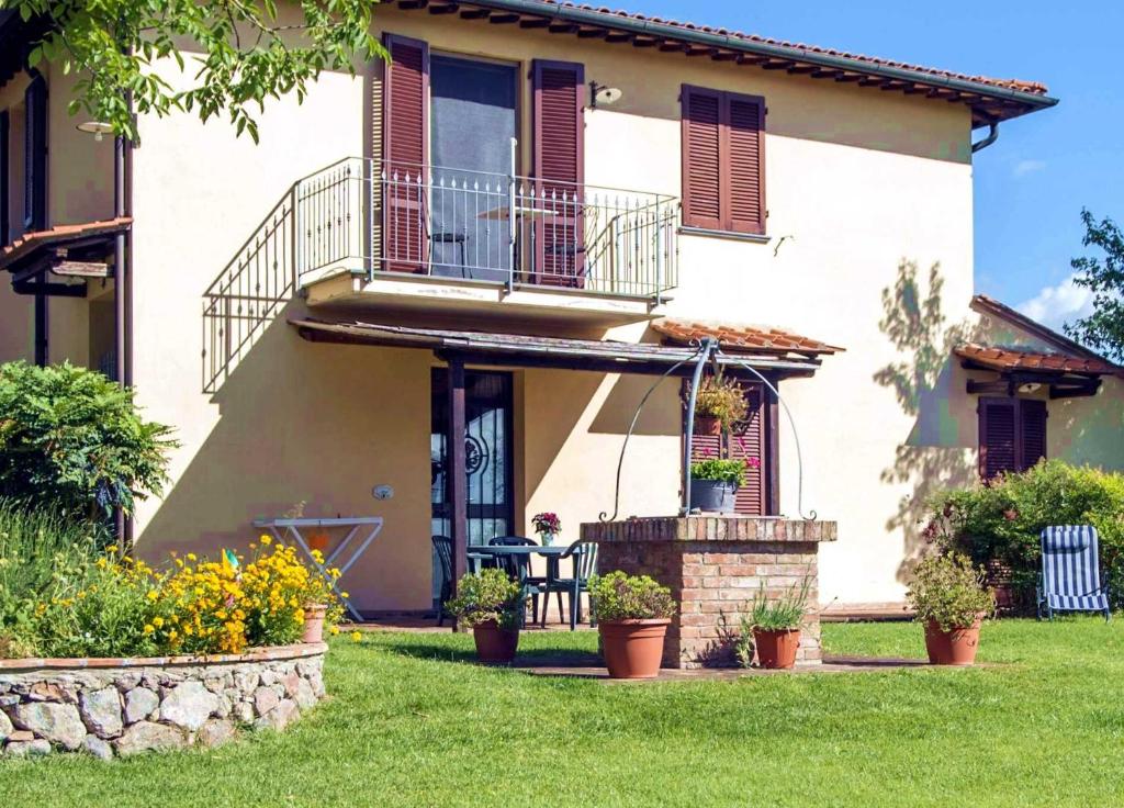 una casa con balcón y plantas en un patio en Agriturismo Il Poggetto, en San Gimignano