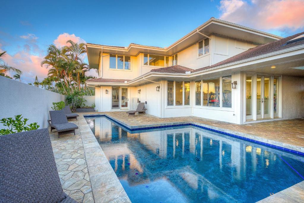 a house with a swimming pool in front of a house at Aloha 'Ohana home in Koloa