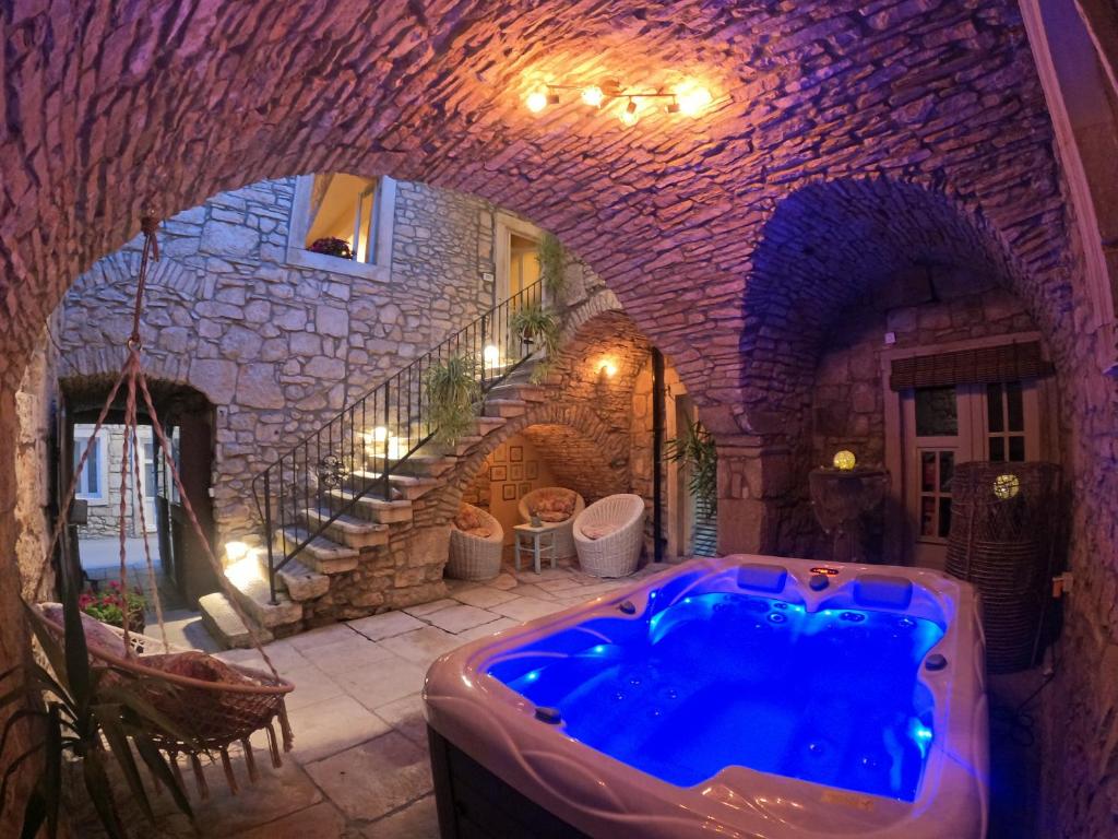 a large bathroom with a blue tub in a stone building at Stone House Hedonia in Blato