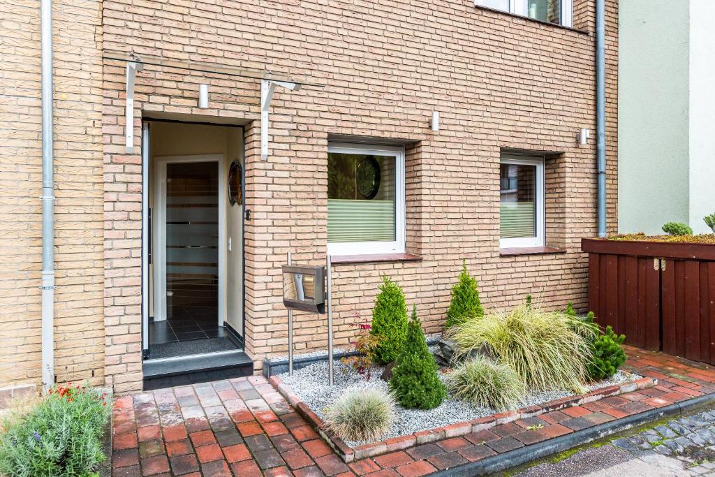 a brick house with a door and some plants at Design Apartment in Köln mit Terrasse in Cologne