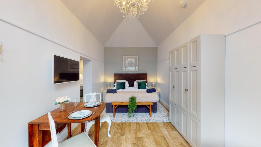 a bedroom with a bed and a table and a dining room at Hidden Jewel Retreat in Budleigh Salterton