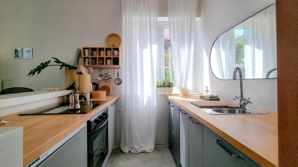 eine Küche mit einem Waschbecken und einem Spiegel in der Unterkunft Arte no5 in Novigrad Istria